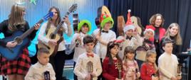 Galeria 21 zdjęć - uczniowie odświętnie ubrani grają na gitarach kolędy i pastorałki - 19.12.2025