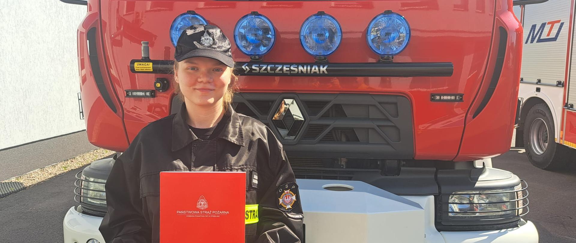 strażak na tle samochodu pożarniczego