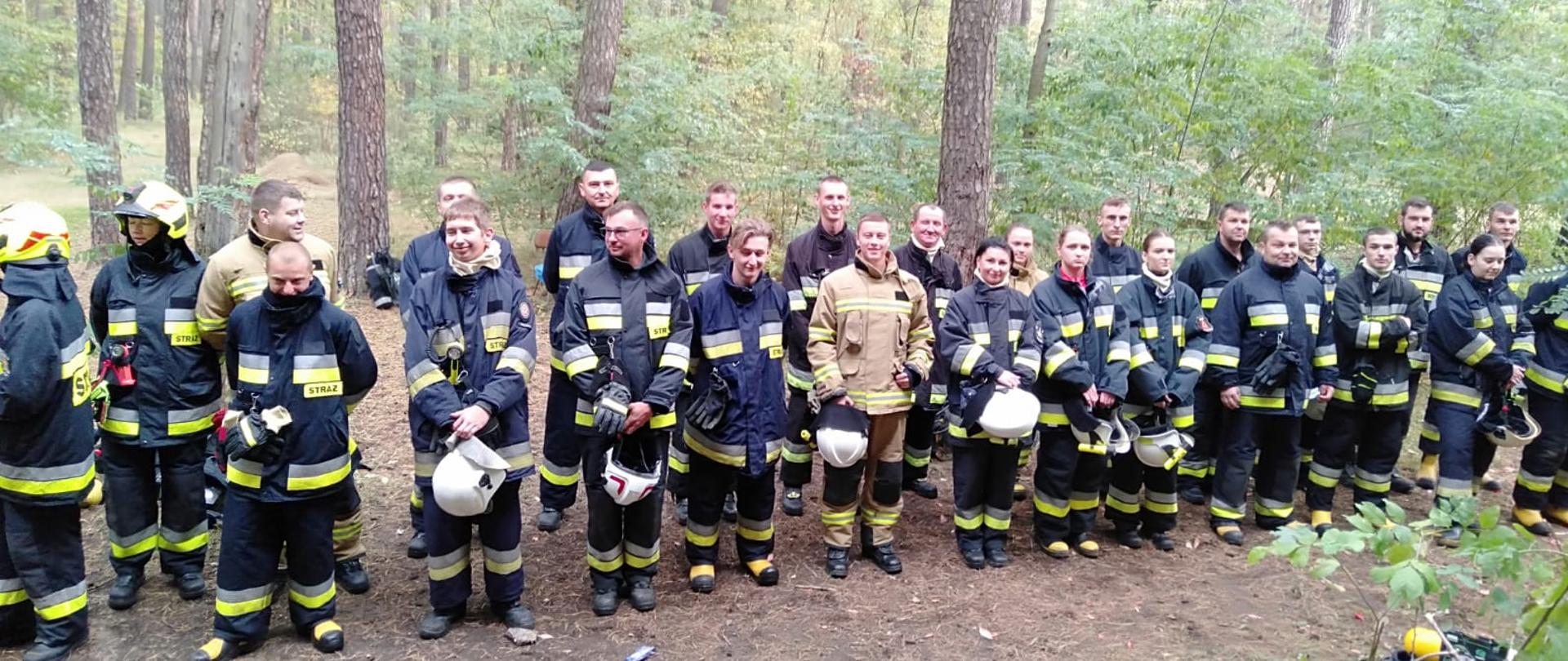 Druhowie OSP ubrani w ubrania specjalne, podczas zbiórki.