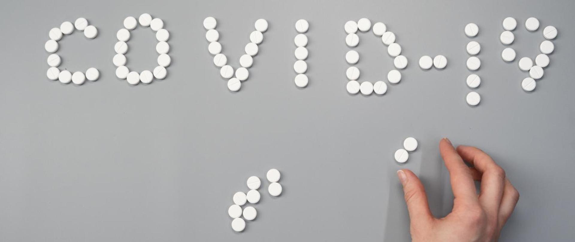 grafika napis COVID 19 ułożony z pastylek