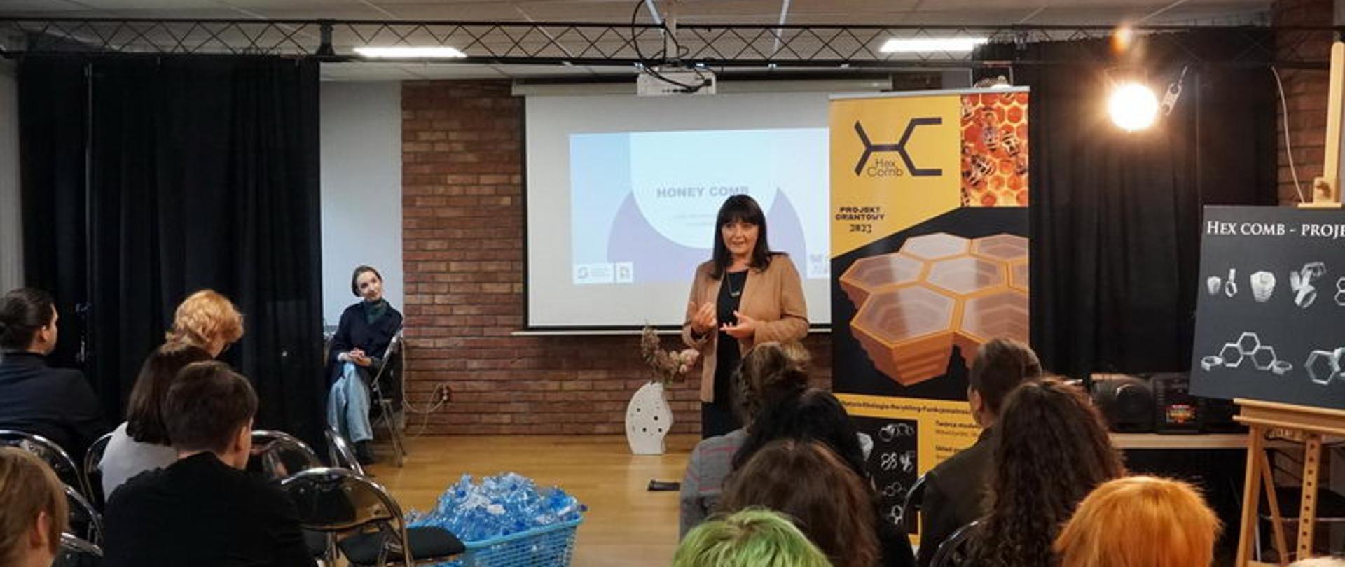 na zdjęciu widzimy panią Dyrektor naszej szkoły przemawiającą do gości i nauczycieli i uczniów naszej szkoły na sali teatralnej