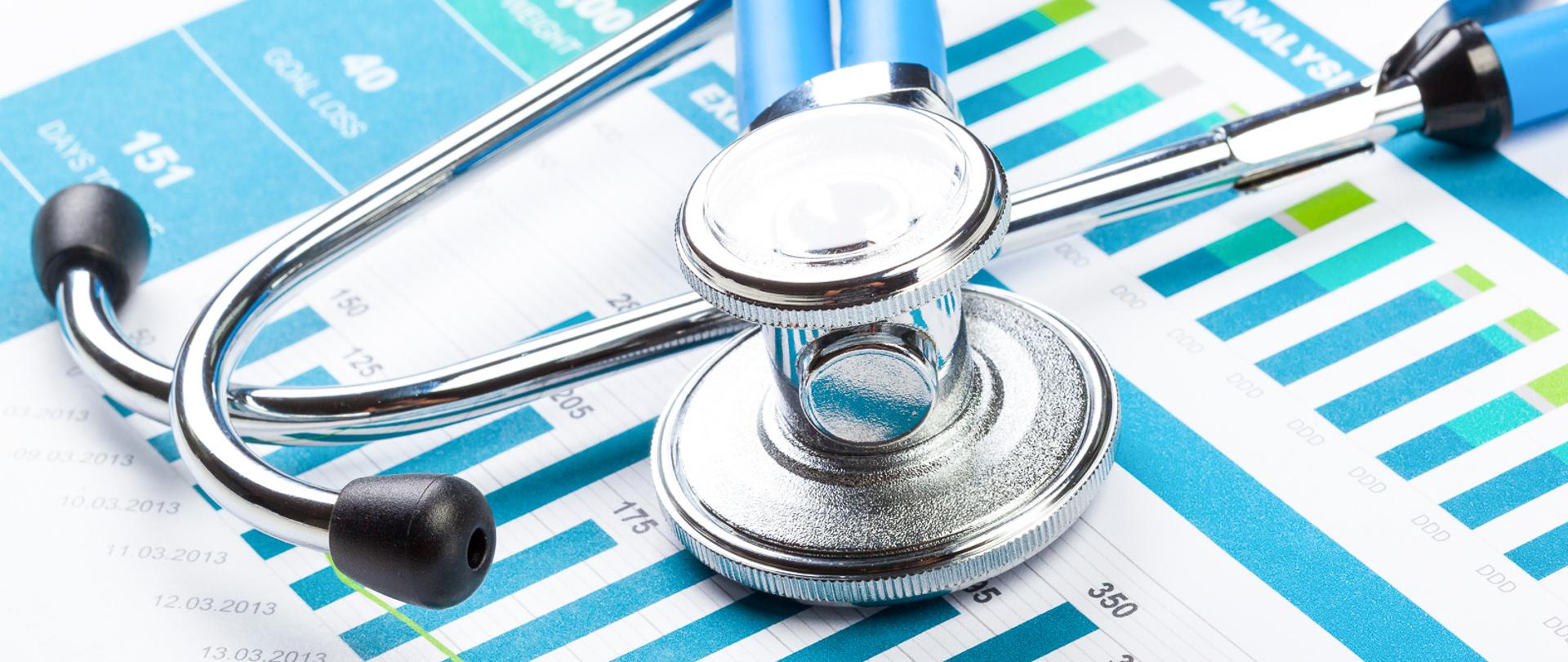 Stethoscope with financial on the desk.