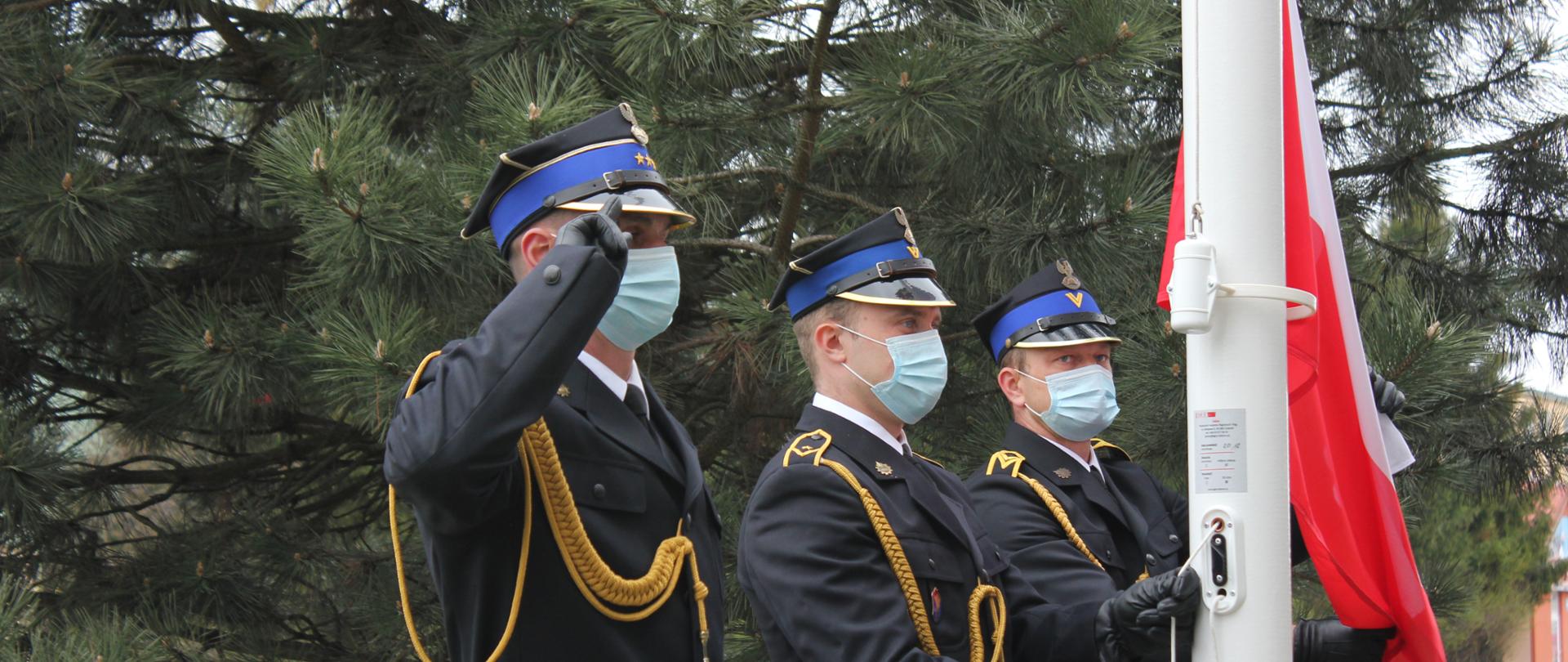 Poczet flagowy podczas podniesienia flagi państwowej. Dowódca oddaje honory, flagowy wraz z asystentem przystępują do podniesienia flagi.