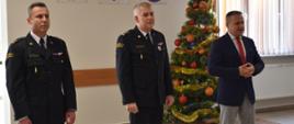 Zdjęcie obrazuje p.o. Zastępcę Świętokrzyskiego Komendanta Wojewódzkiego PSP w Kielcach st. bryg. Marcina Machowskiego, Starostę Powiatu skarżyskiego pan Artura Berusa, p. o. Komendanta Powiatowego PSP w Skarżysku-Kamiennej mł. bryg. Marcina Jasińskiego. Wszyscy biorą udział w spotkaniu opłatkowym w KP PSP w Skarżysku-Kamiennej.