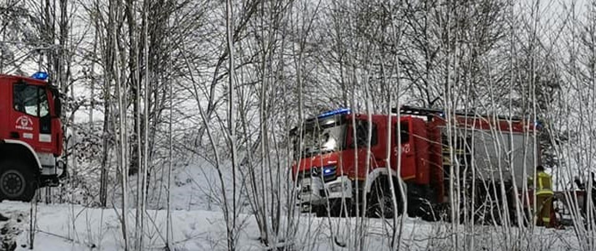 Samochody pożarnicze stojące na skarpie.