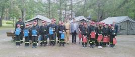 Zdjęcie podczas zbiórki wszystkich uczestników podczas wizytacji, w tle obozowisko namiotowe.