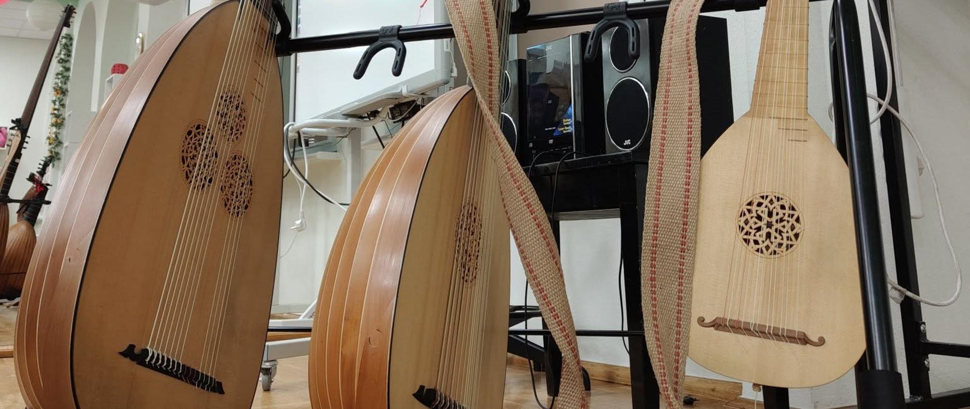 Lutnie ustawione na statywie podczas pokazu dla uczniów. 