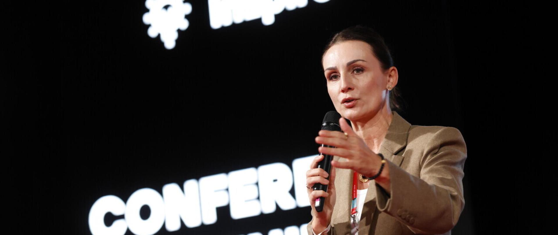 kobieta trzyma w ręku mikrofon i przemawia