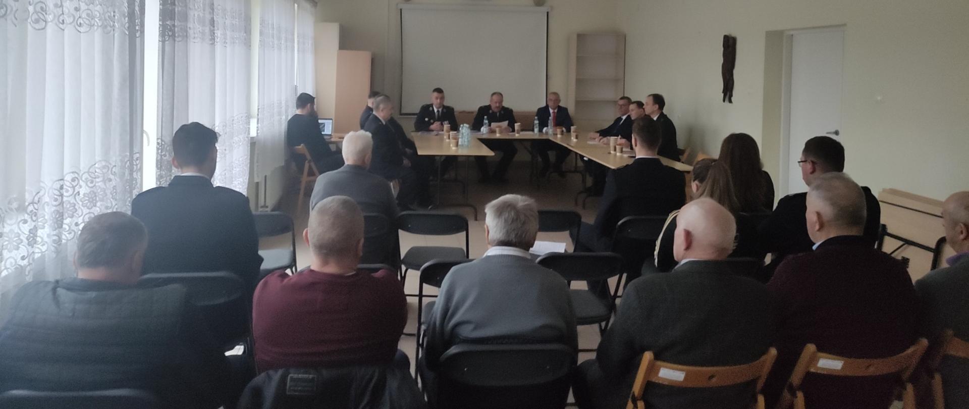 Zdjęcie przedstawia gości, organizatorów oraz zgromadzonych uczestników spotkania sprawozdawczego Ochotniczej Straży Pożarnej w Ciekotach.