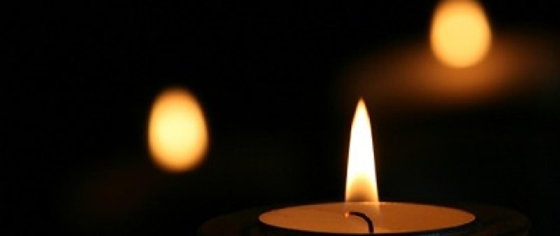 Palący się znicz na czarnym tle