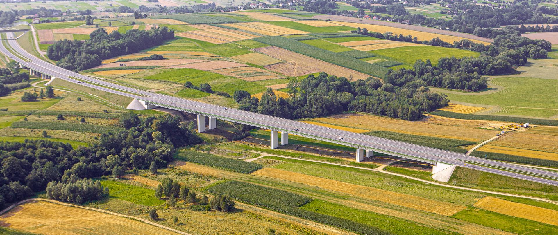 Fotografia lotnicza drogi ekspresowej S1. Centralna część fotografii obrazuje most o długości ponad 322 m nad potokiem Wieśniak w gminie Wilkowice.