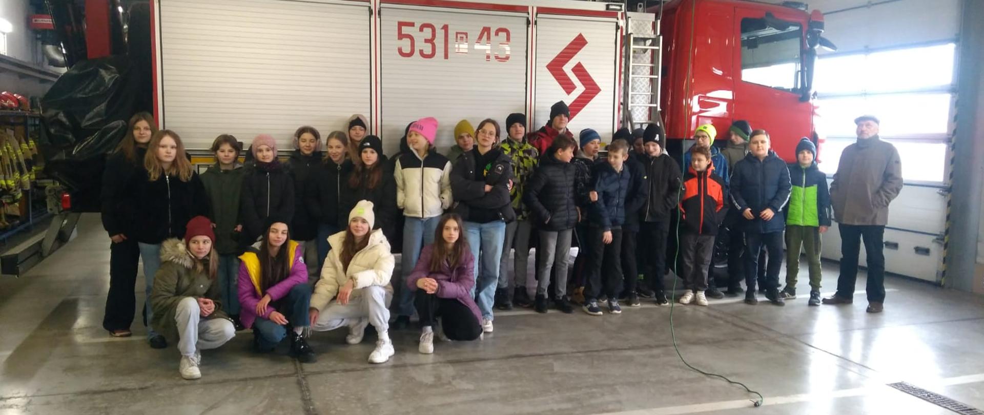 Dzieci na tle samochodu strażackeigo