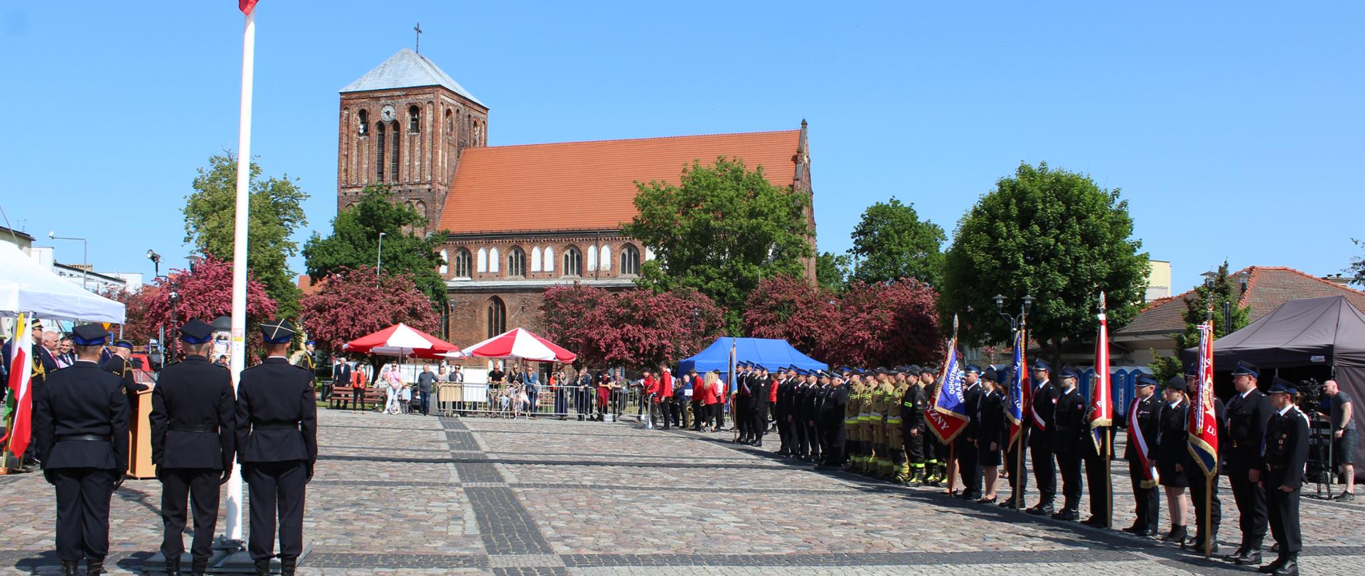 Fotografia przedstawia rynek miejski w Strzelcach krajeńskich, a na nim ustawione pododdziały do uroczystego apelu.