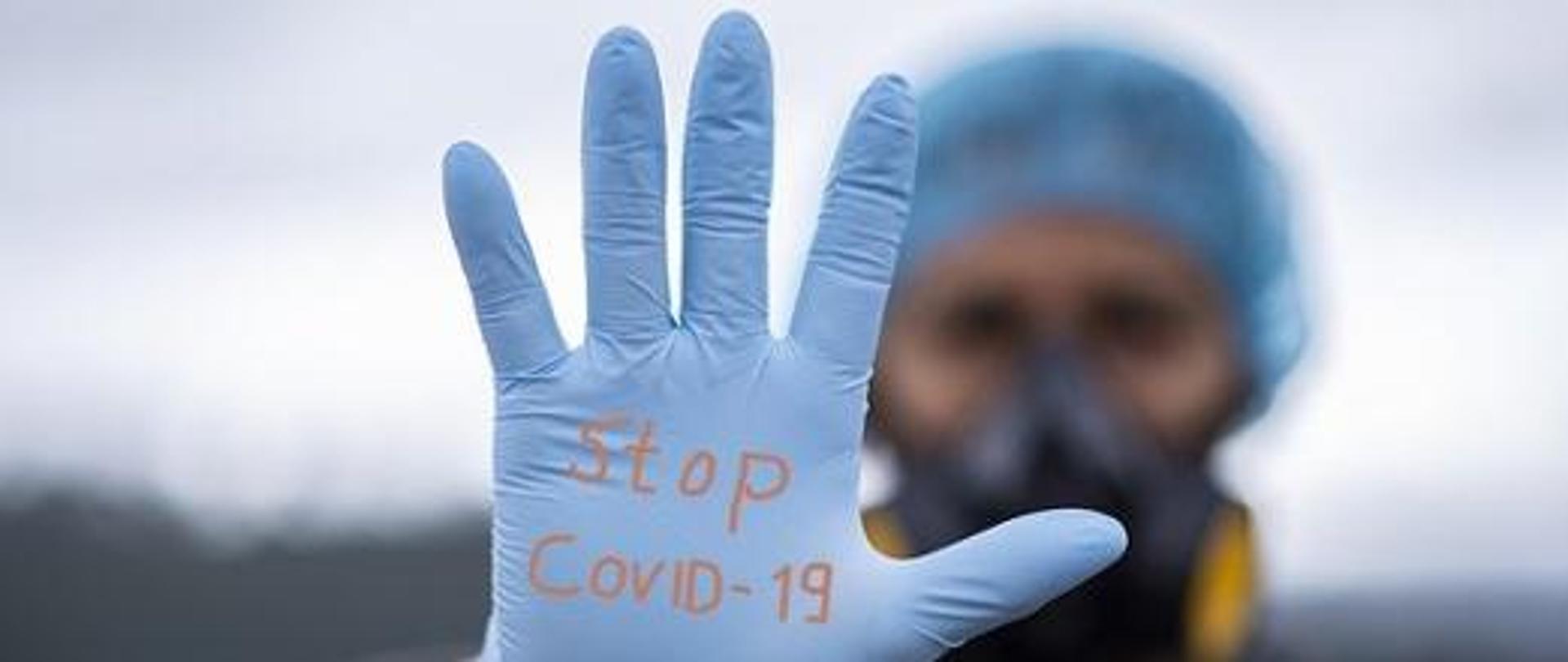 dłoń z napisem stop covid-19