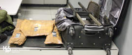 Na zdjęciu walizka, w której były przemycane narkotyki, obok niej 5 kg narkotyków zapakowanych w folię