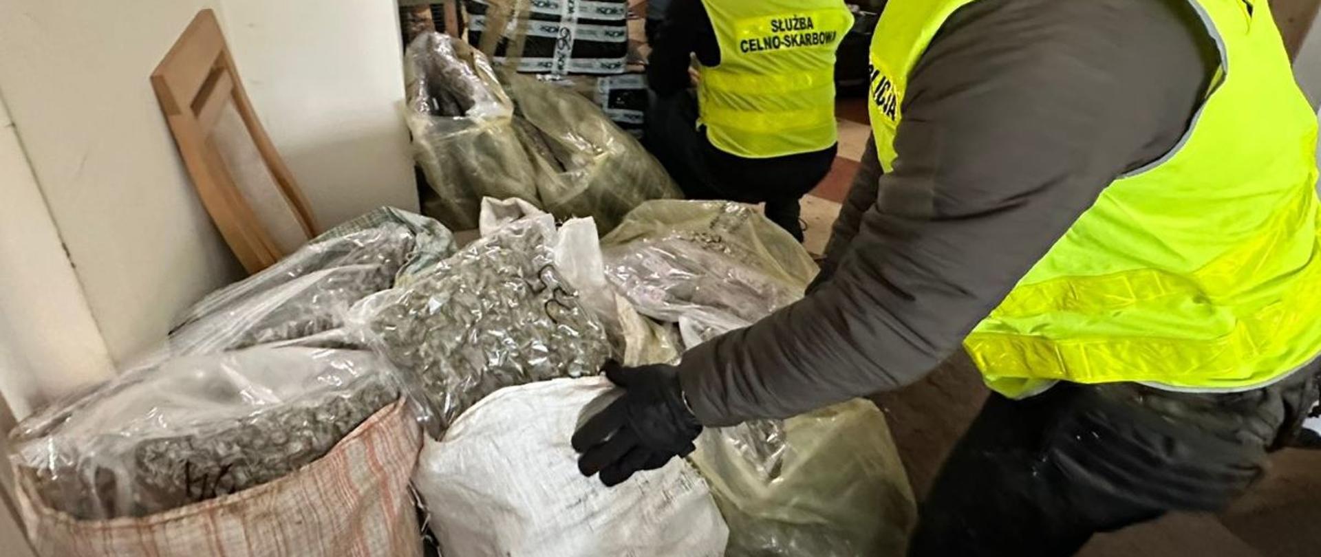 funkcjonariusze przy workach z narkotykmi