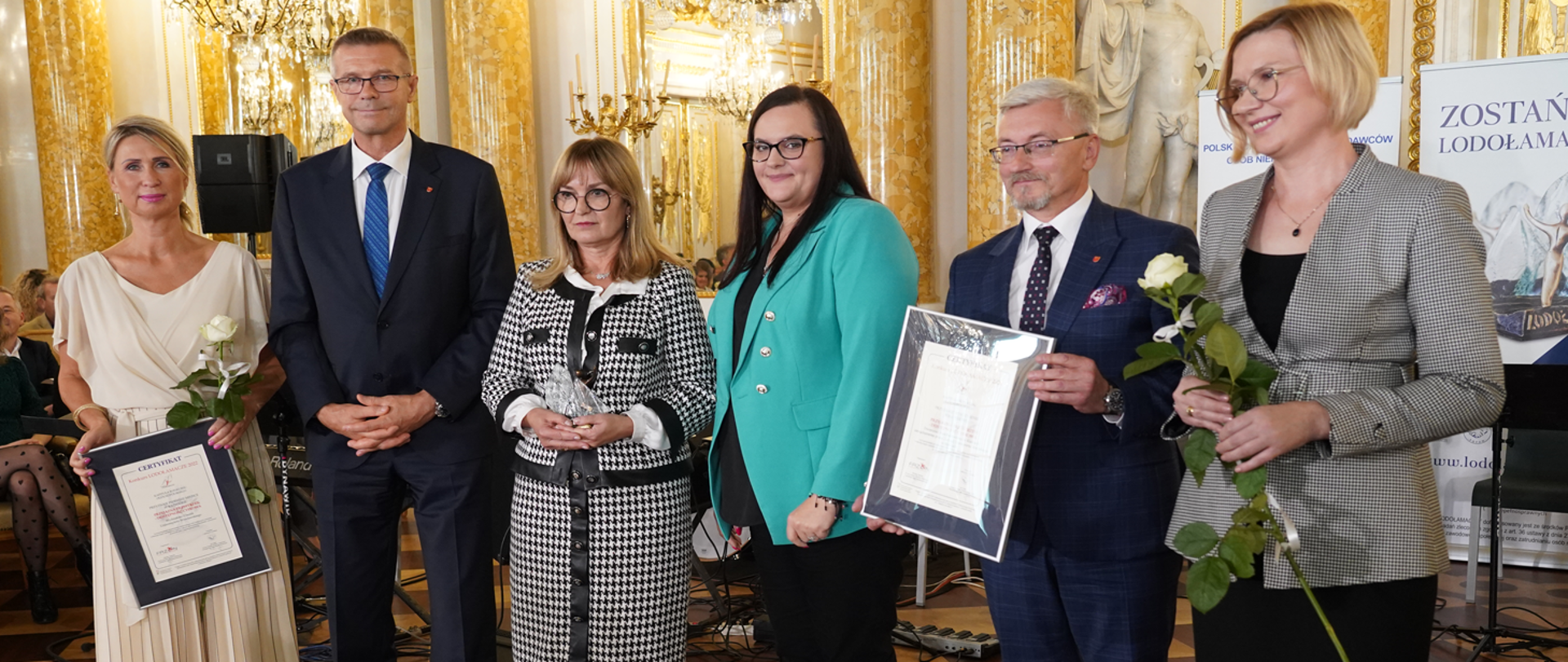 Grupa osób pozuje do zdjęcia w sali Zamku Królewskiego. W środku wiceminister Małgorzata Jarosińska-Jedynak.