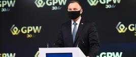 Prezydent RP Andrzej Duda stojący przy mównicy i wygłaszający przemówienie z okazji 30. rocznicy inauguracyjnej sesji Giełdy Papierów Wartościowych w Warszawie