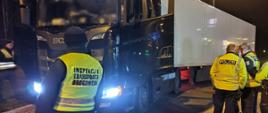 Od lewej: umundurowani inspektorzy lubuskiej Inspekcji Transportu Drogowego i niemieccy policjanci z Brandenburgii stoją obok zatrzymanego do kontroli ciągnika siodłowego z podpiętą naczepą.