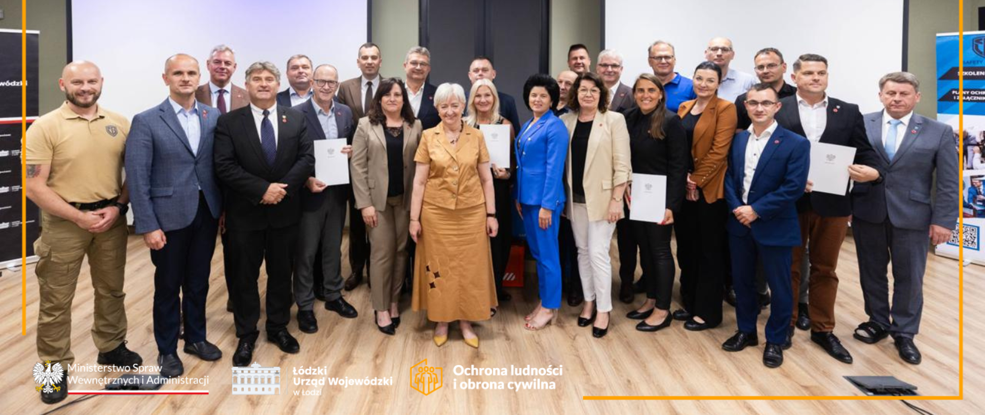 Pamiątkowa fotografia wojewody łódzkiego Doroty Ryl z samorządowcami, którzy ukończyli szkolenie o ochronie ludności i obronie cywilnej 