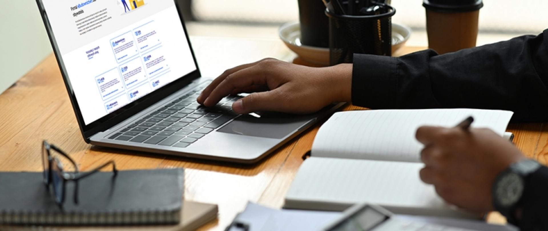 Laptop z otwartą stroną internetową portalu eBudownictwo, prezentujący interfejs użytkownika i dostępne funkcje cyfrowe.