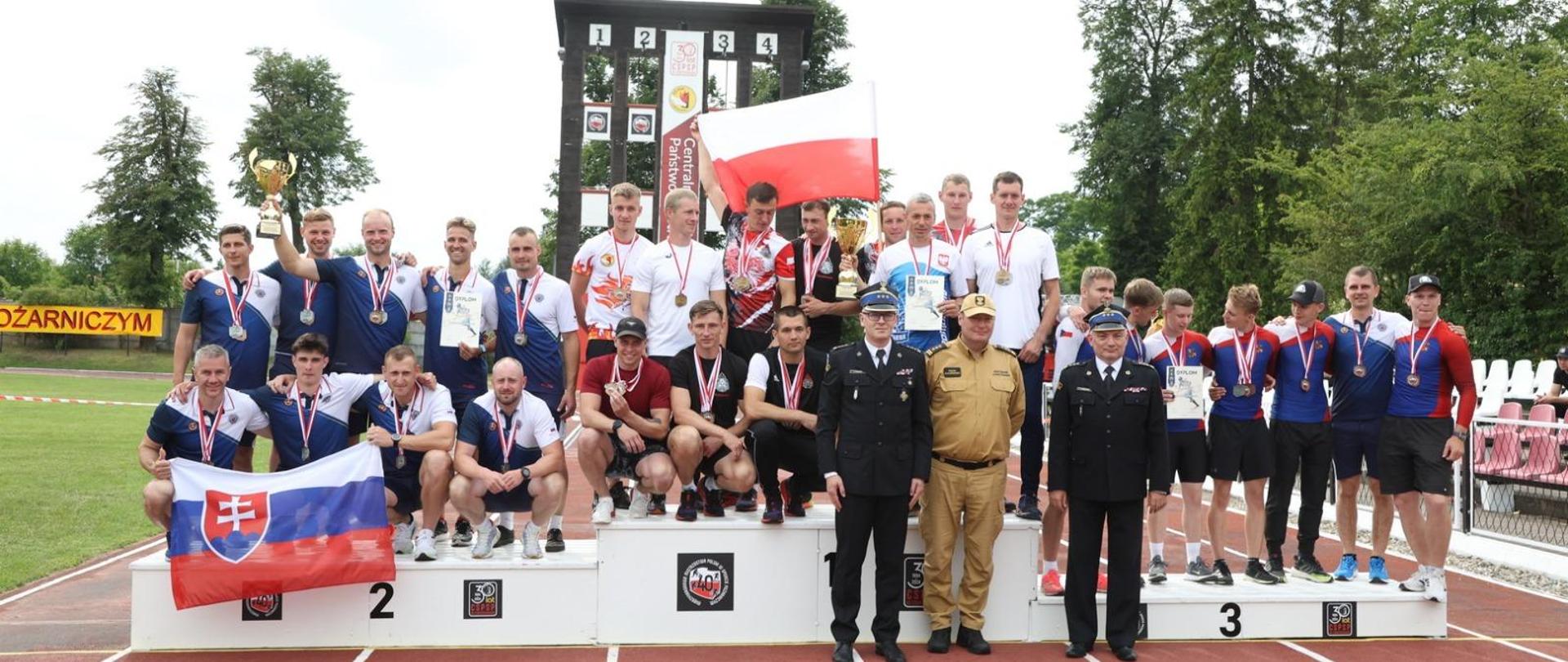 zastępca komendanta głównego i komendant szkoły na wspólnym zdjęciu z zawodnikami na podium