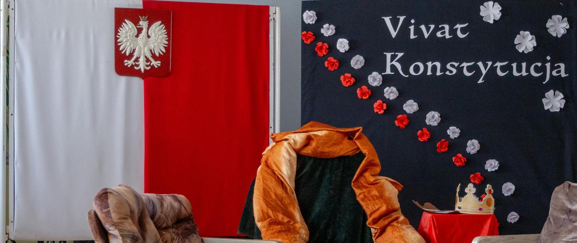 Tron i trzy fotele na tle ekranów z polską flagą i godłem oraz napisem na granatowym tle Vivat Konstytucja