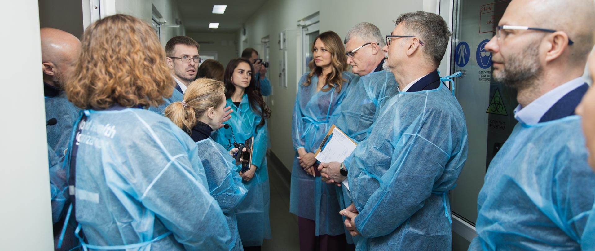 ludzie w odzieży ochronnej stoją na korytarzu szpitala