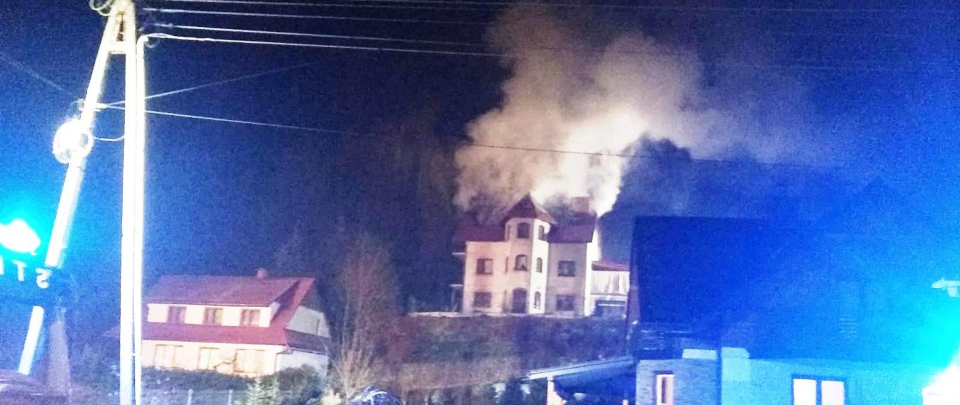 Dymy wydobywające się z budynku mieszkalnego na wzgórzu