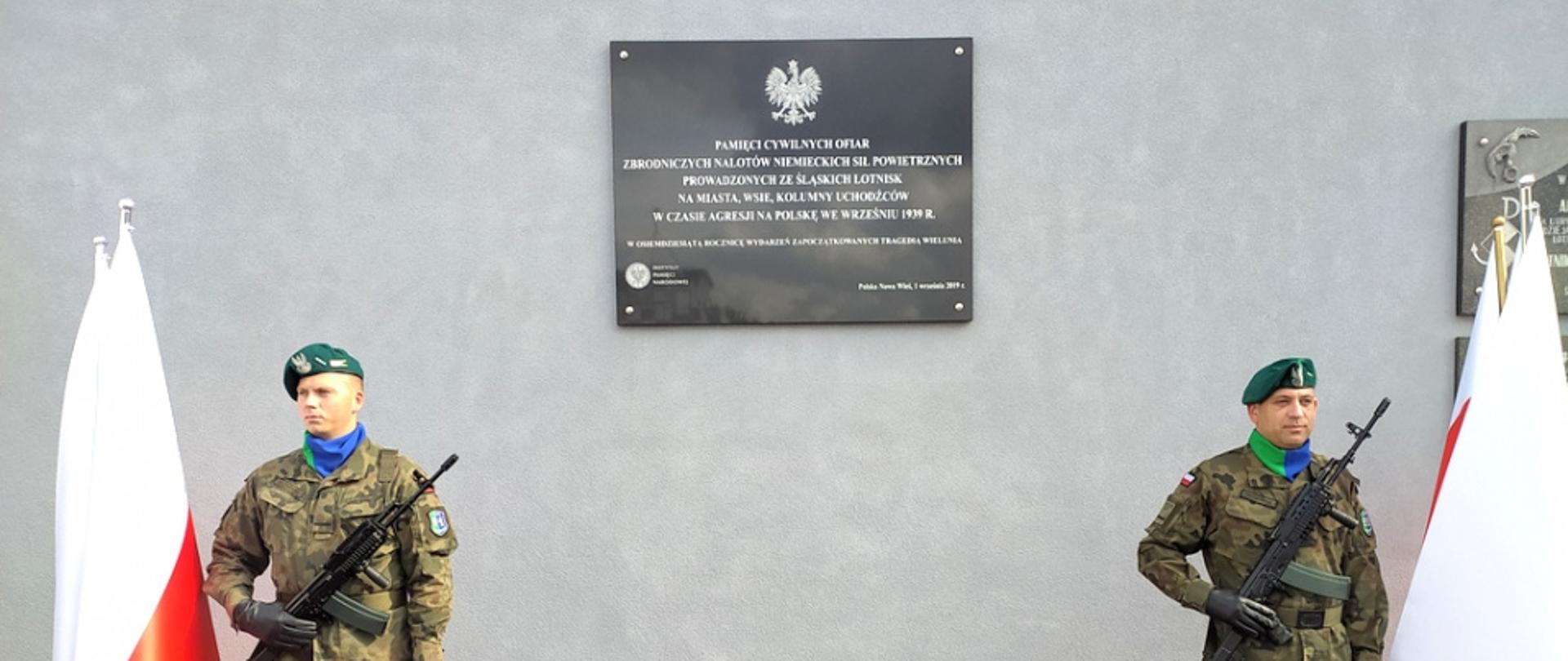 Dwóch żołnierzy stojących przed pomnikiem 