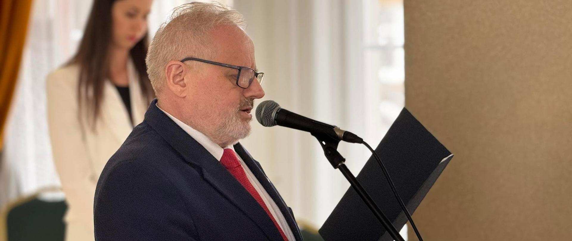 Mężczyzna w garniturze, wicewojewoda, odczytuje list 