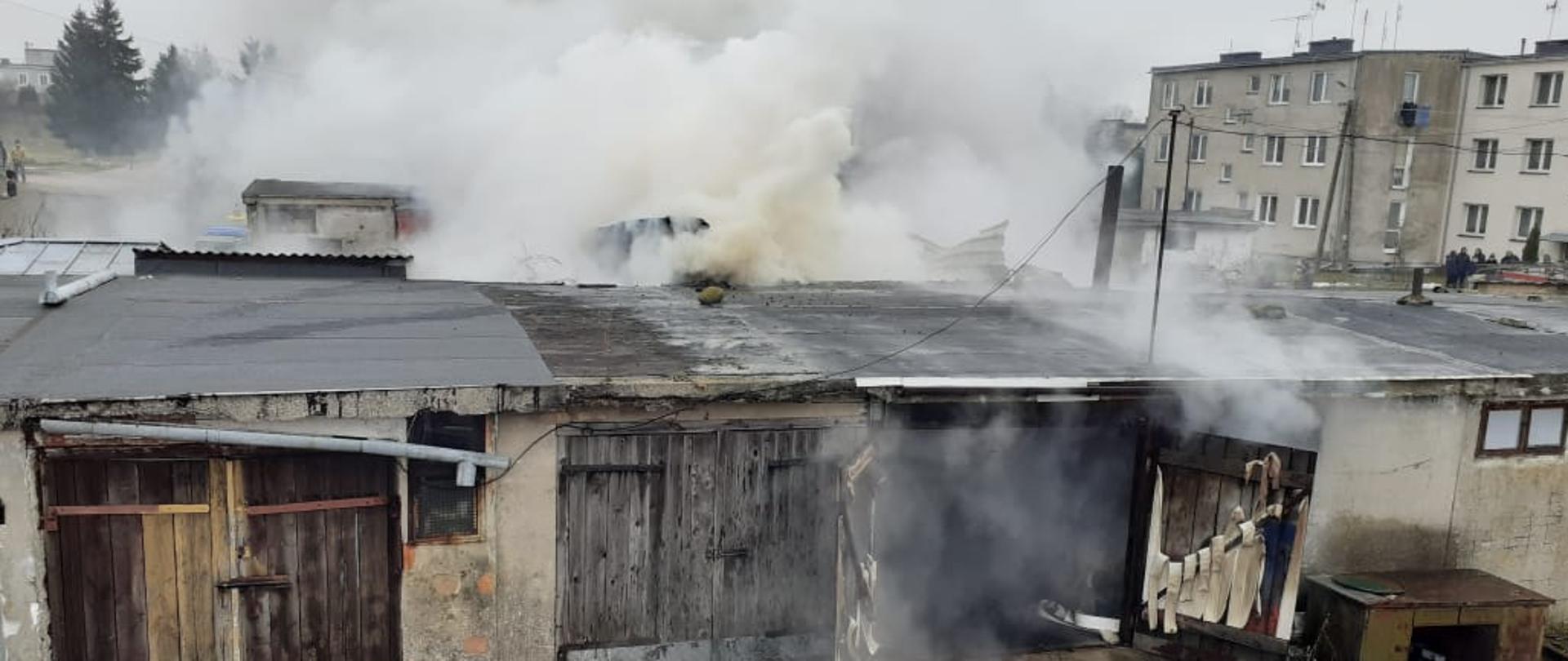 Dym wydobywający się z garażu, w tle budynek wielorodzinny