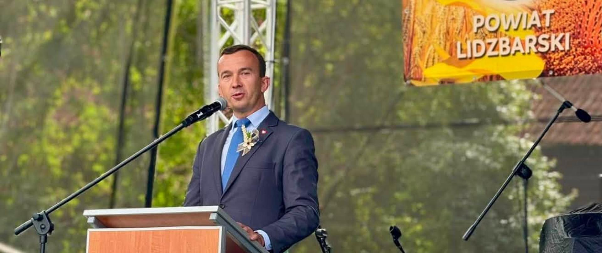 Mężczyzna przemawia zza mównicy 