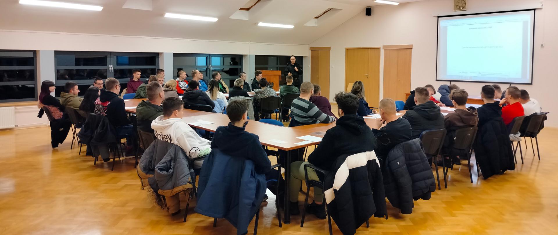 Zdjęcie przedstawia kursantów na sali podczas wykładu. 