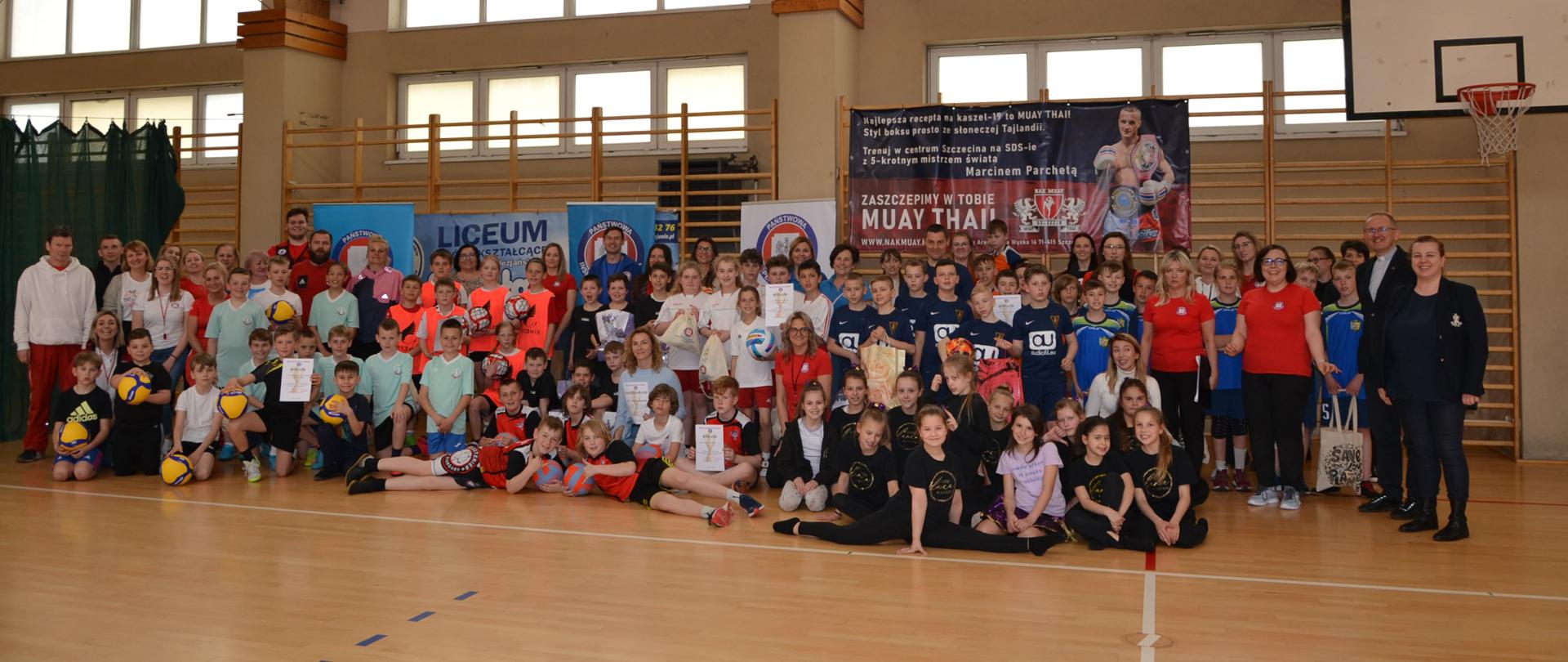 Pomieszczenie, uczestnicy turnieju na pamiątkowym zdjęciu.