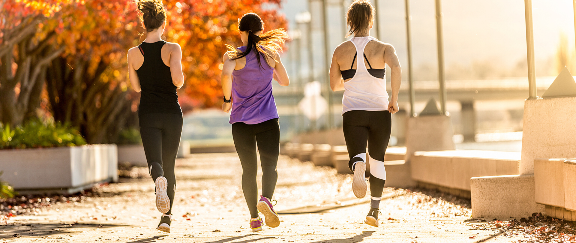 Trzy kobiety biegnące przez park