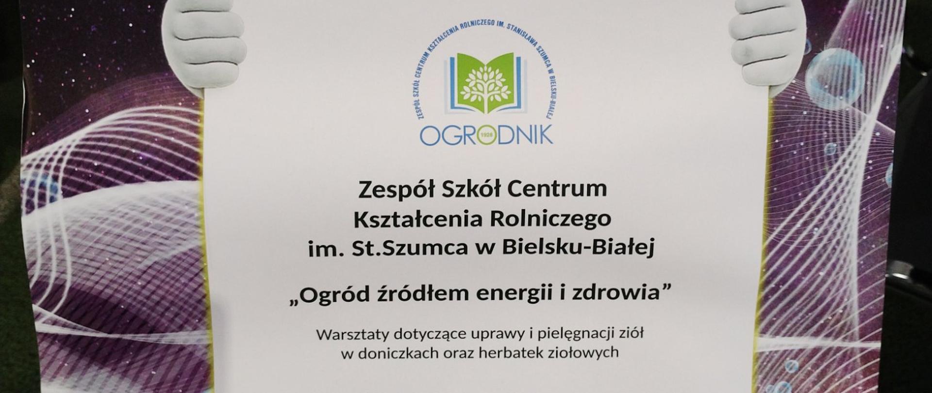 Plakat 16. Beskidzkiego Festiwalu Dobrej Energii z rysunkową postacią o białej, okrągłej głowie w czerwonej czapce i zielonym stroju, trzymającą duży szyld. W tle ciemne, abstrakcyjne światła i żółte okręgi przypominające żarówki. Na plakacie widoczne są informacje o warsztatach dotyczących uprawy i pielęgnacji ziół oraz logotypy organizatorów.
