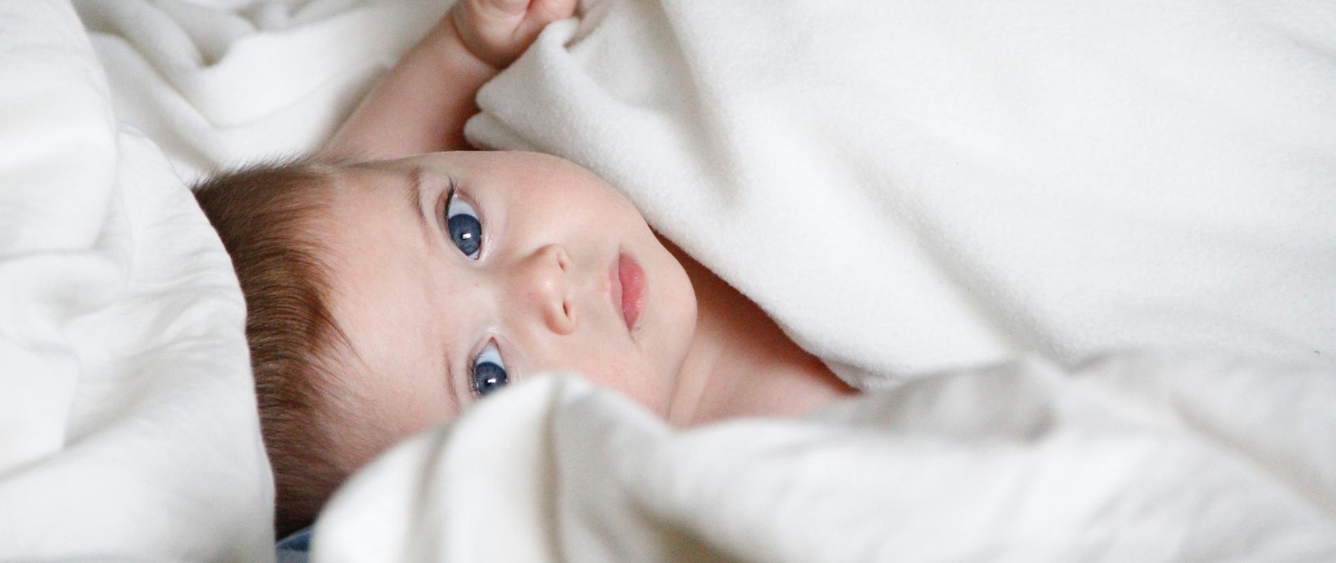 Dziecko w pościeli leżące na łóżku