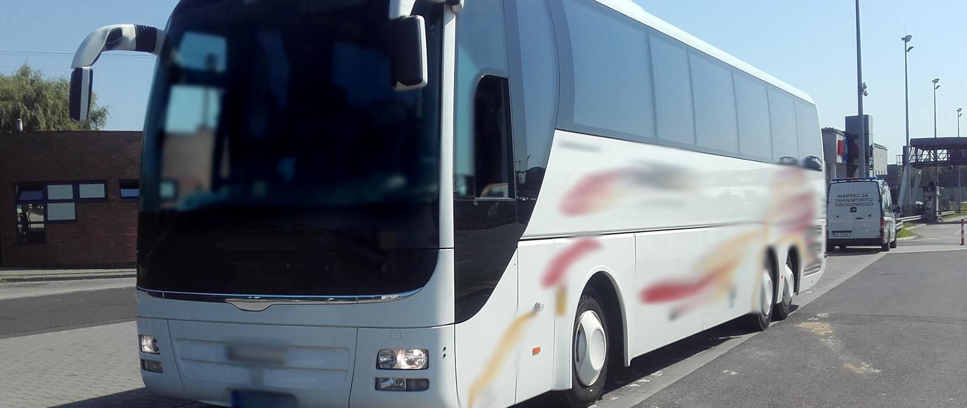 Na pierwszym planie: zatrzymany do kontroli drogowej autobus wycieczkowy z pasażerami. W tle: oznakowany furgon małopolskiej ITD.