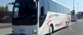 Na pierwszym planie: zatrzymany do kontroli drogowej autobus wycieczkowy z pasażerami. W tle: oznakowany furgon małopolskiej ITD.