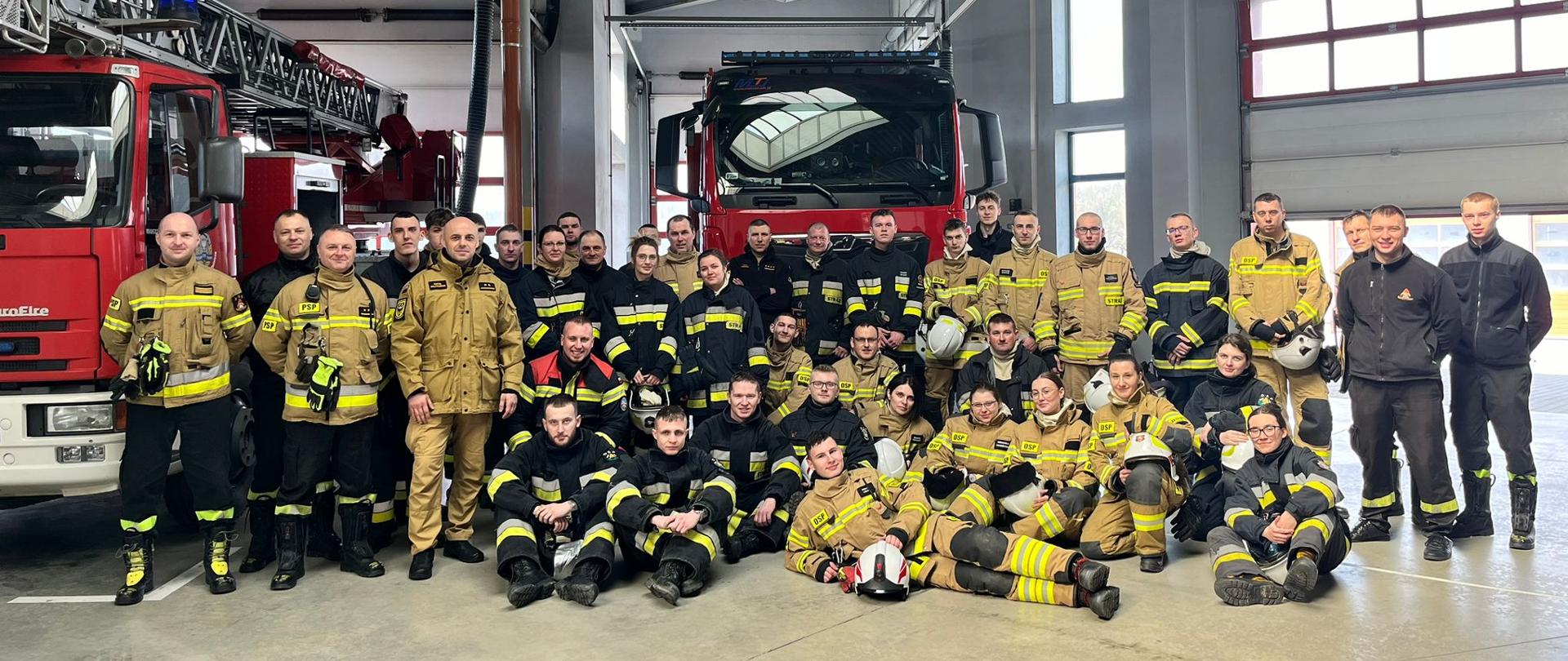 wspólne grupowe zdjęcie strażaków w mundurach na garażu JRG