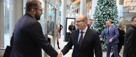 Minister funduszy i polityki regionalnej Grzegorz Puda na konferencji inaugurującej Fundusze Europejskie dla Podlaskiego 2021-2027, minister Puda wita się z marszałkiem województwa podlaskiego Arturem Kosickim
