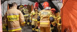 Zdjęcie ukazuje punkt udzielania pomocy poszkodowanym. W środku jego znajdują się strażacy Ochotniczej Straży Pożarnej wraz z Wojskową Strażą Pożarną.