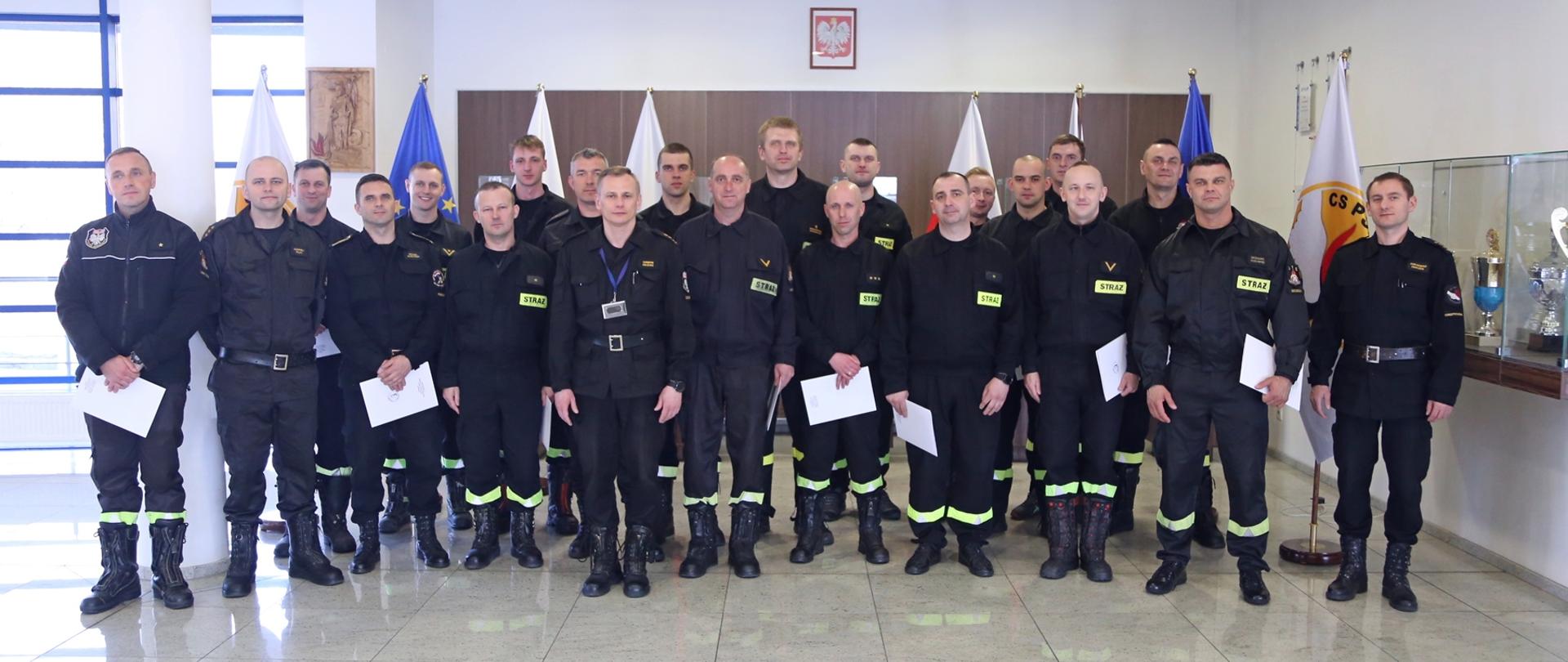 Grupowe zdjęcie uczestników szkolenia w towarzystwie Zastępcy Komendanta Centralnej Szkoły PSP oraz zastępcy naczelnika wydziału szkoleń specjalistycznych i współpracy międzynarodowej