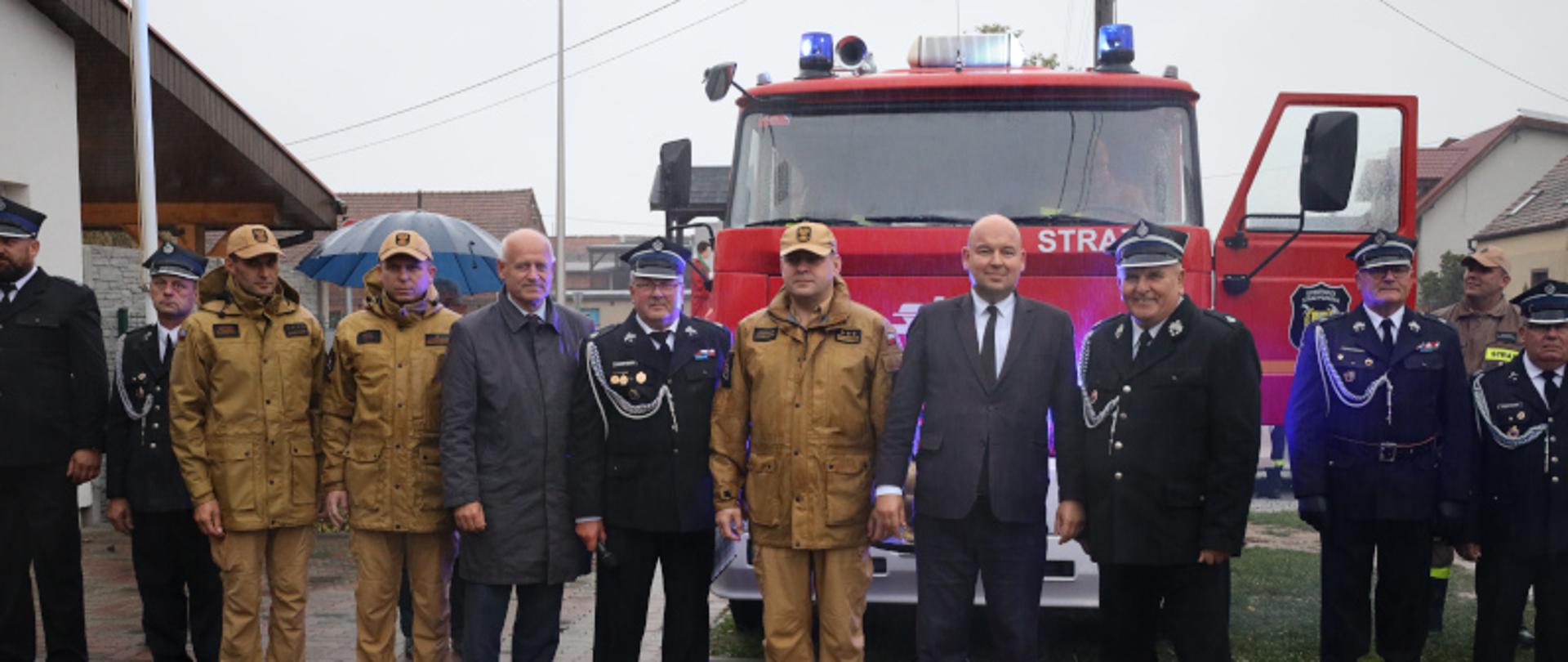 Zdjęcie przedstawia strażaków oraz pozostałych zebranych gości przekazujących pojazd jednostce Bonikowo. W tle pojazd pożarniczy,