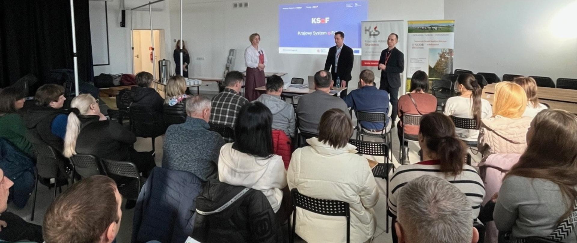 W sali siedzi grupa osób i słucha wykładu o podatkach