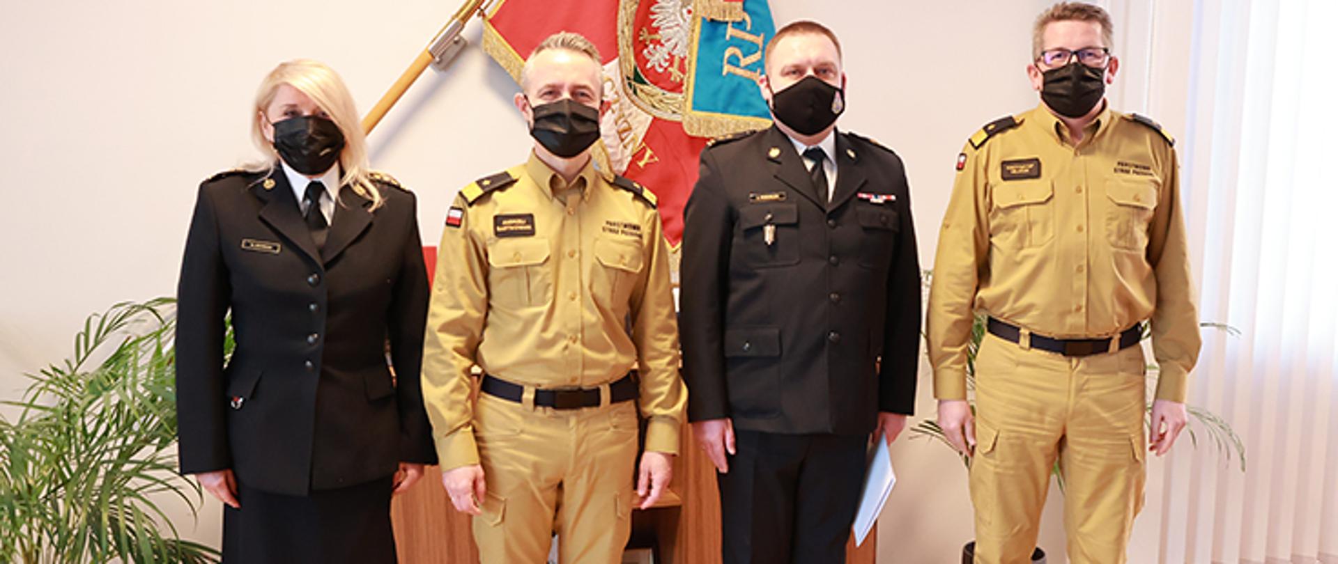 Czterech funkcjonariuszy (w tym jedna kobieta , pierwsza po lewej stronie) w umundurowaniu podczas uroczystości wręczenia mianowania na stanowisko zastępcy dyrektora