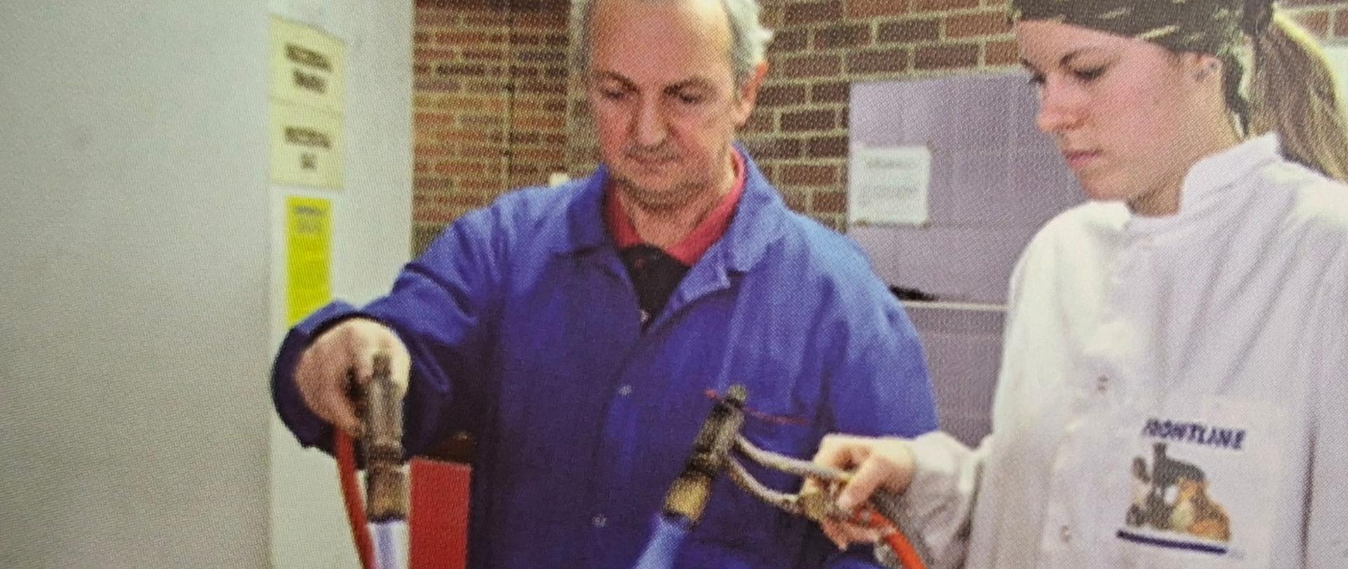 Fotografia przedstawiająca Profesora Alfreda Pogorzałka z uczennicą w pracowni metaloplastyki