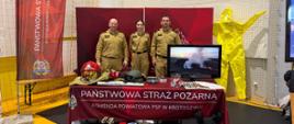 Zdjęcie przedstawia funkcjonariuszy PSP na stoisku podczas targów edukacyjnych.