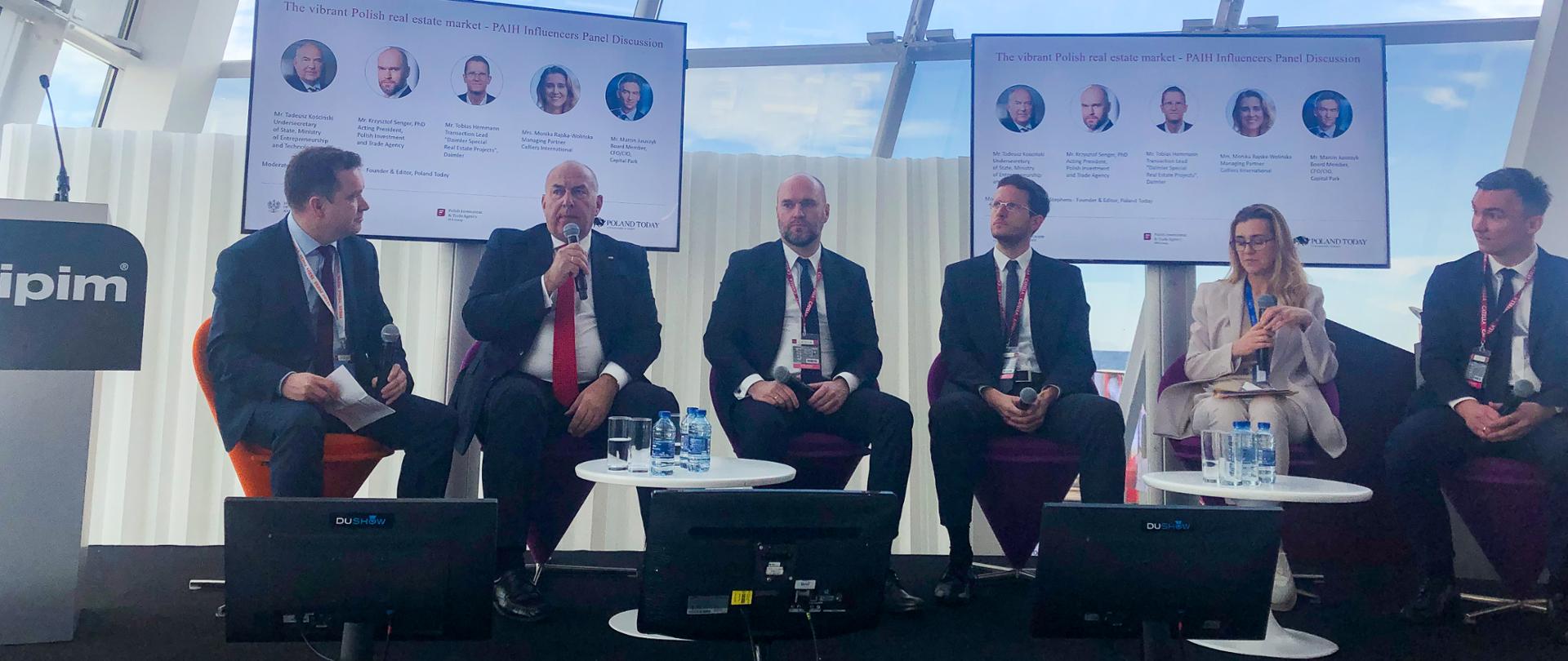 Minister Tadeusz Kościński siedzi wśród panelistów podczas debaty na targach MIPIM2019